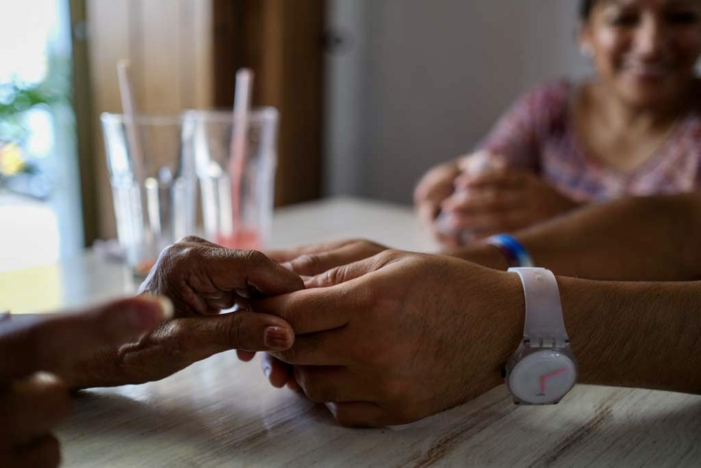 Two pairs of hands meeting across a table